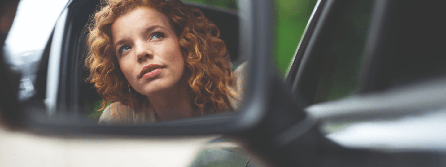 Frau schaut aus Autofenster.