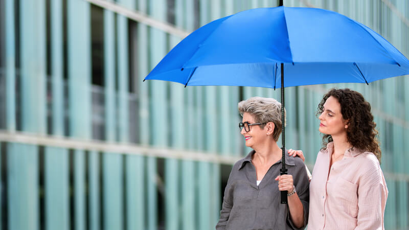 Zwei Damen unter einem blauen Schirm